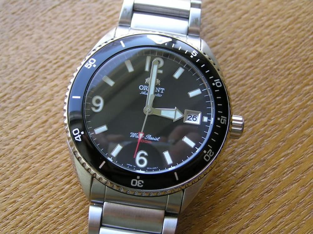 Orient Dolphin bền bỉ với dây thép không gỉ và mặt kính cứng, phù hợp cho môi trường nước biển